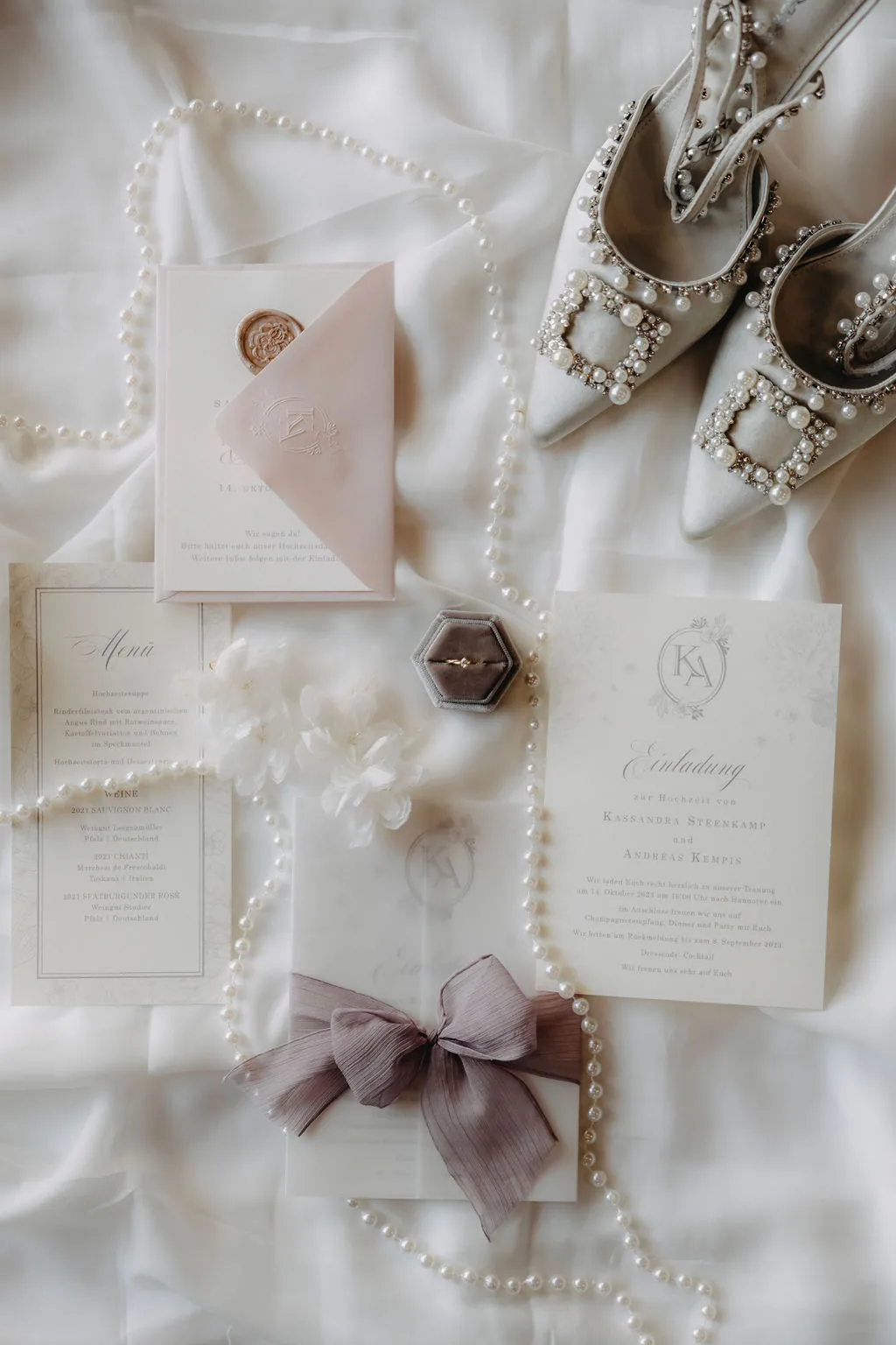 Einladungssuite in Creme mit Perlenkette, Wachssiegel und Seidenschleife